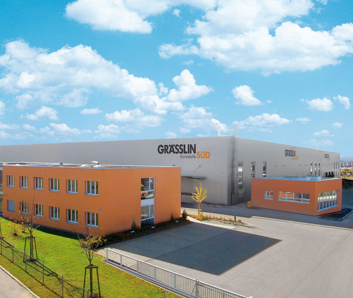 Industriegebäude von Grässlin Kunststoffe Süd mit blauem Himmel im Hintergrund.