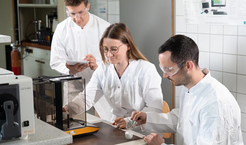 Wissenschaftler in Laborkitteln bei Experimenten im Labor, präzise Messungen und Teamarbeit für Forschung und Entwicklung.